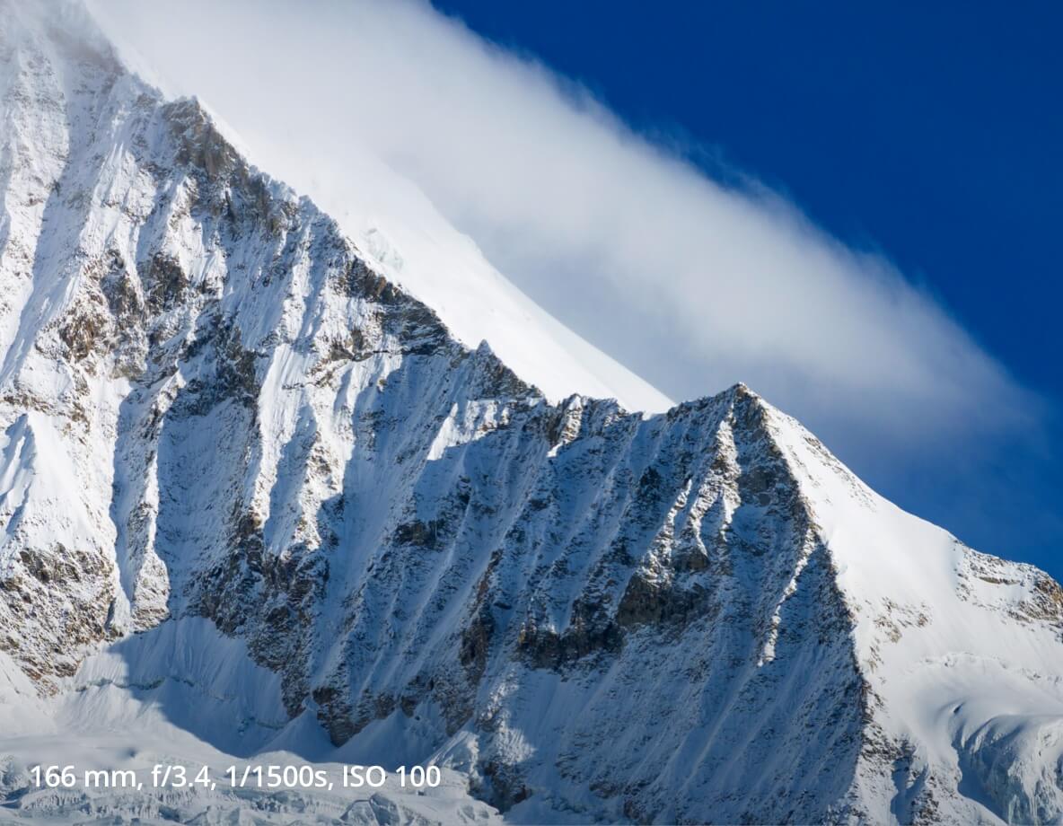 166 mm, f3.4, 1/1500s, ISO 100 photo of snow covered cliffs taken on the 1/2