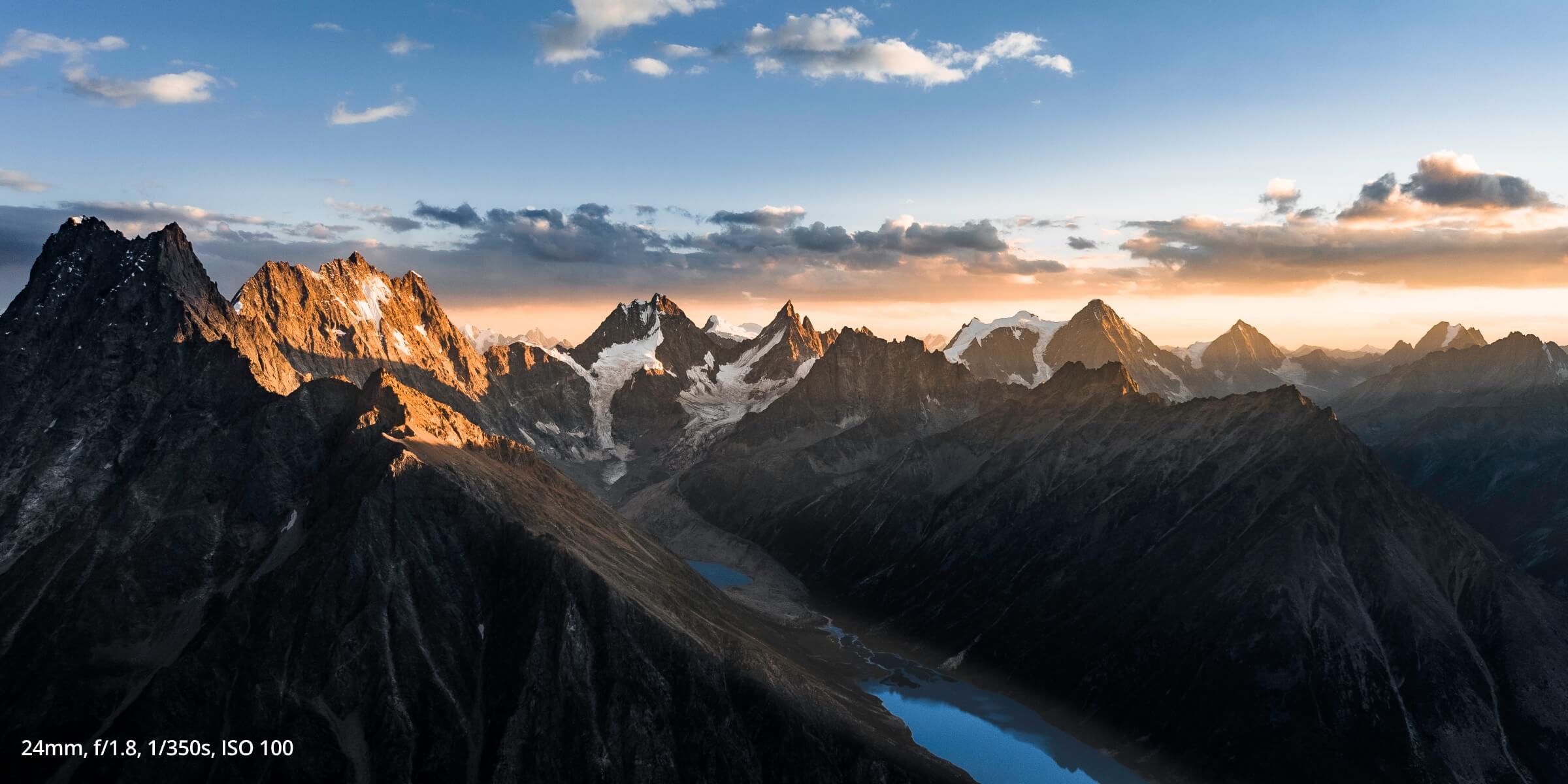 Air 3S photo of multiple mountains and a lake at sunset taken with settings of: 24mm, f/1.8m 1/350s, ISO 100
